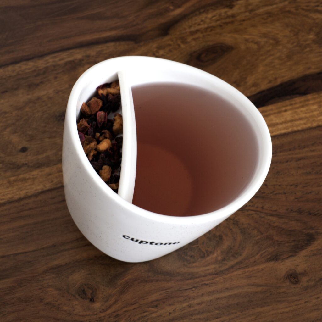 Top view of tilting teacup filled with herbal tea